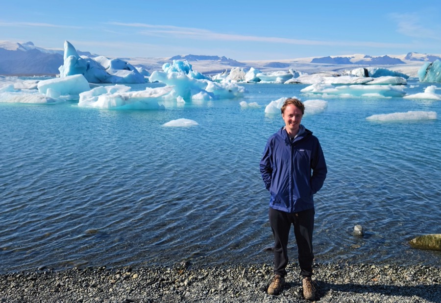 Shane Draper standing by a glacier lagoon in Iceland